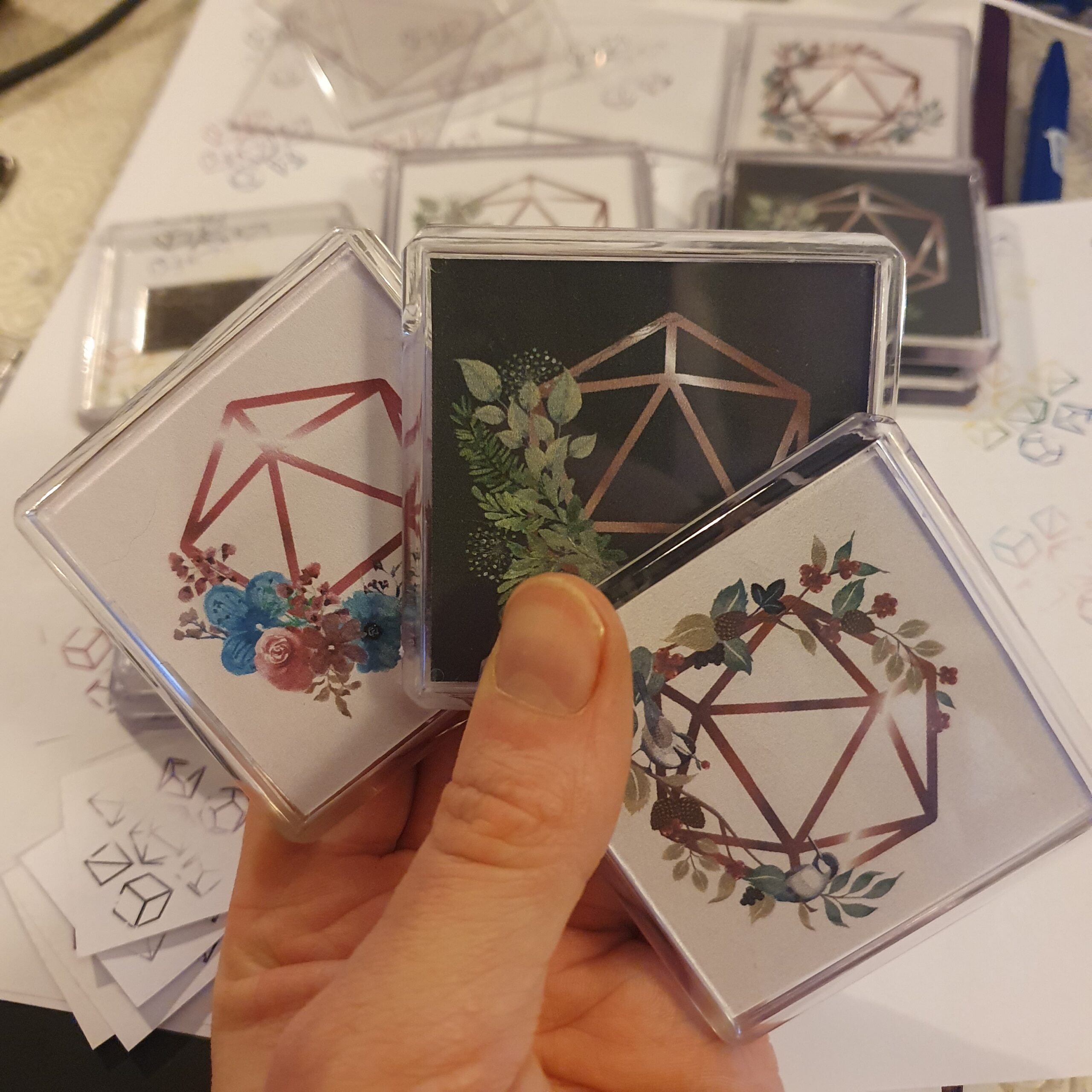 Three magnets containing a line image of a d20